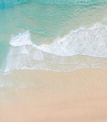 Aerial view of a beach with idyllic tropical blue water and gentle waves 