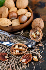 Fototapeta na wymiar Open walnut and nut cracker on burlap. Close-up. selective focus