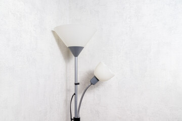 floor lamp standing in the corner against the background of light wallpaper