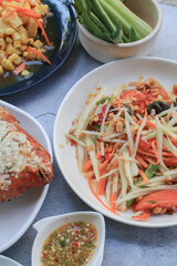 Thai papaya salad, Som Tum, Spicy green papaya salad with vegetables on table. Famous Thai food. Asian food style