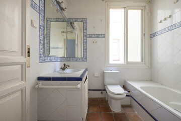Bathroom with vintage style white tiles with blue borders and blue patterned borders