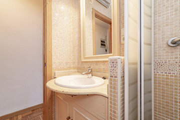 Bathroom with cream marble top and mirror with wooden frame and shower tray with gresite tile and...