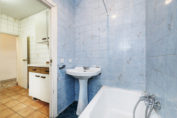 Very used vintage bathroom with access to a kitchen in the same condition