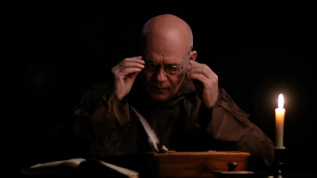 Video of old monk takes a manuscript out of the document box, signs it and puts it back.