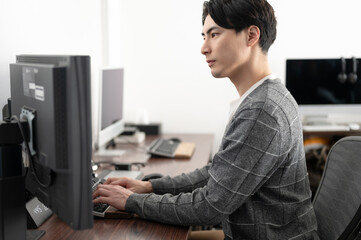 パソコンを操作する男性　デザイン　プログラマー