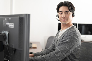 デスクトップPCを操作する男性　オペレーター　テレワーク