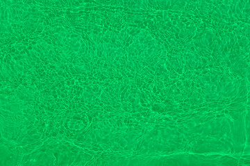 Defocus blurred transparent green colored clear calm water surface texture with splashes and bubbles. Trendy abstract nature background. Water waves in sunlight with copy space. Green water shine