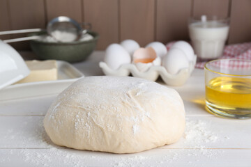 Fresh yeast dough and ingredients on white wooden table