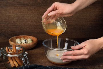 Woman mixing ingredients at wooden table, closeup. Cooking delicious eggnog