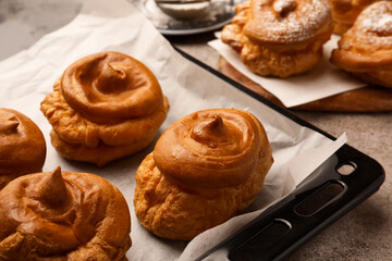 Freshly baked delicious profiteroles on grey table, closeup
