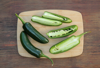 Fresh green jalapeno peppers on wooden table, top view