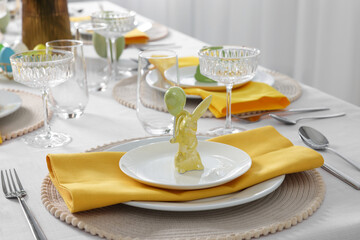 Festive table setting with cutlery, plate and bunny figure. Easter celebration