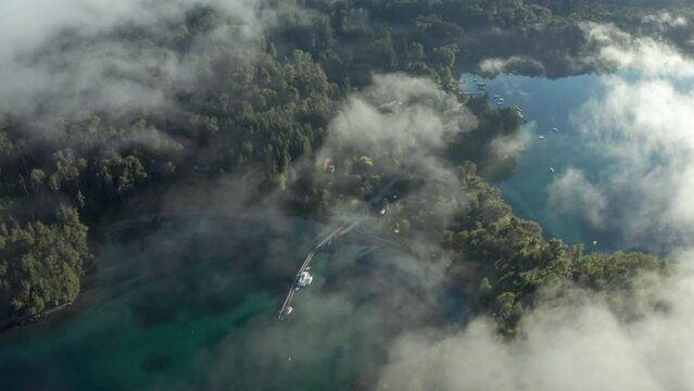 AERIAL - Nahuel Huapi Lake through the clouds in Arrayanes National Park, Neuquen, Argentina, forward truck right
