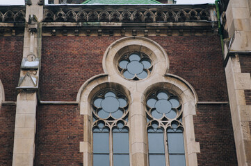 Round window with stained glass on facade of the building. Baroque and Gothic architecture. Church...