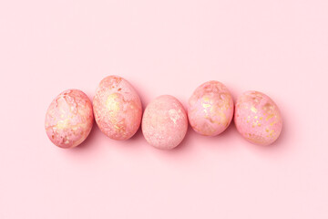 Pink Easter eggs row, pastel Easter background. Monochrome greeting card, flat lay, copy space.