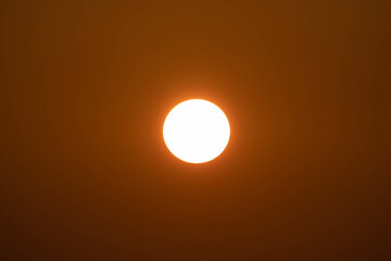 Closeup of bright big sun on the sky with yellow orange gradient colors during the sunset