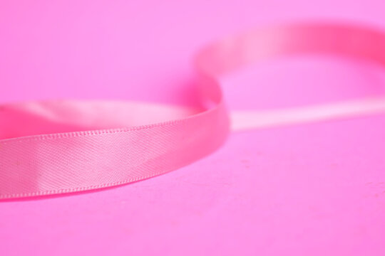 Macro shot of pink ribbon on pink background