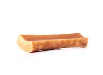 Isolated Yak cheese dog chew bone. Sideview of yellow orange dog chew stick made of yak milk. Snack...
