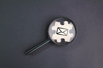 magnifying glass and wooden puzzle with email icon. the concept of finding email.