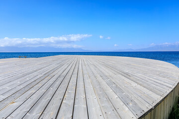 Fototapeta na wymiar Empty wooden square with clear lake natural background in Xinjiang, China.