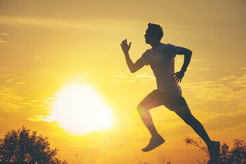 Silhouette of young man running sprinting on road. Fit runner fitness runner during outdoor workout with sunset background.