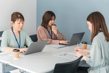 Obraz premium フリーアドレスオフィスで自由に仕事するビジネスウーマン（シェアオフィス・コワーキングスペース） 