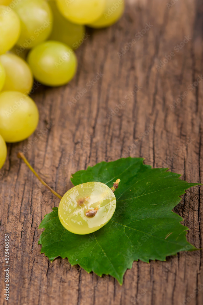 Canvas Prints Juicy green grapes - macro shot of whole and cut berries on wooden background