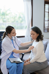 Obraz premium Portrait of a female doctor using a stethoscope to check the pulse of an elderly patient.