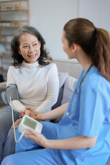 Portrait of female doctor measuring patient's blood pressure before treatment.