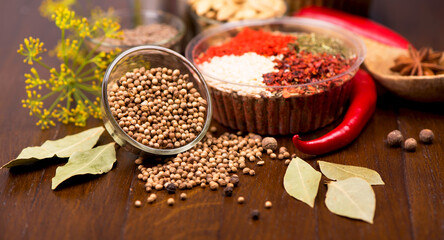 Set of spices and herbs. Indian food. Pepper, salt, paprika, basil, turmeric. On a black wooden board. View from above. Free copy space.