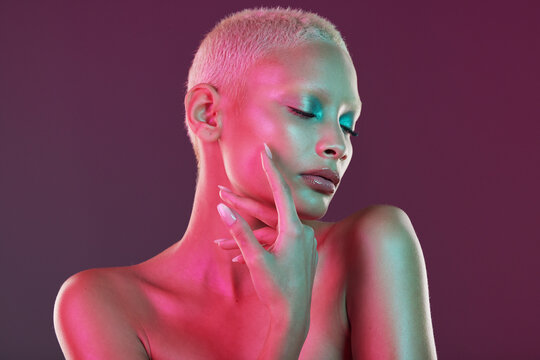 Neon, skincare and beauty, woman with hand in face, makeup and light in creative advertising on studio background. Cyberpunk, art girl and fantasy model isolated in futuristic skin care mockup space
