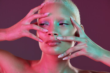 Neon makeup, woman with hands in face, skincare and lights for creative advertising on studio...