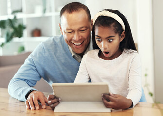 Digital tablet, shock and girl with her father streaming a movie or video online for entertainment. Surprise, technology and child watching a film or show with her dad on mobile device at their home.