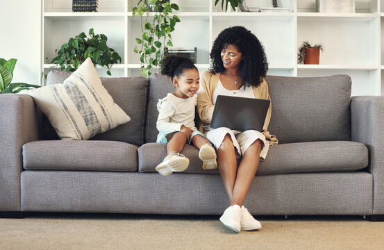 Family, mother and child with laptop in home living room for remote work, online education and wifi. Black woman and girl together on couch with internet for learning, games and watch movies to relax