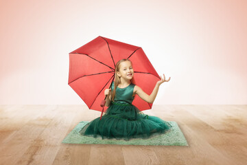 Beautiful happy little girl with red umbrella on pink background.
