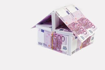 A house built from packs of five hundred euros. Light background.