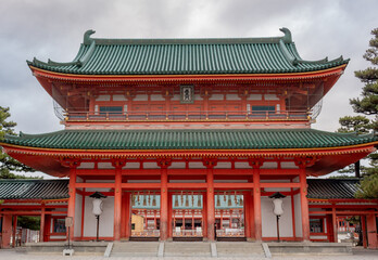 Colorful orange buddhist temple building pagoda structure at Heian Heritage Cultural Shrine in Kyoto Japan on a cloudy day