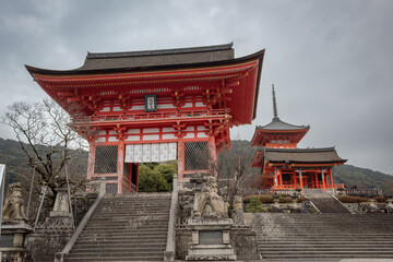 Red Japanese wooden temple building and traditional Buddhist architecture at the Kiyomizu-dera buddhism temple in Kyoto Japan.