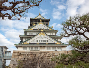 Fototapeta premium Green and white traditional Japanese architecture building of the Osaka Castle in Osaka Japan