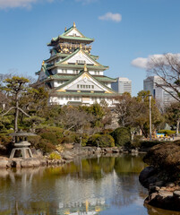 Fototapeta na wymiar Green and white traditional Japanese architecture building and garden park and trees of the Osaka Castle in Osaka Japan