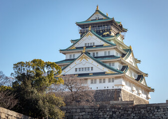 Fototapeta premium Green and white traditional Japanese architecture building of the Osaka Castle in Osaka Japan
