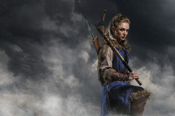 Beautiful female viking woman warrior in battle with ax and bow with arrows. Amazon fantasy blonde - 573419331