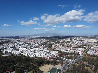 a drone photo aerial view of the city in puebla, mexico, hispanic downtown with the blue sky, clouds and travel 