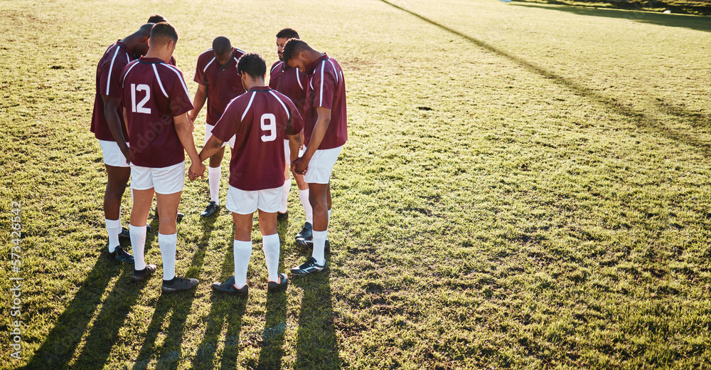 Wall mural Men, huddle and team holding hands praying on grass field for sports coordination or collaboration outdoors. Group of sport players in fitness training, planning or getting ready for game on mockup