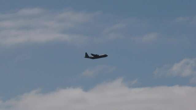 c130 flying over beach - close up