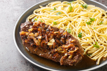 Zwiebelrostbraten Swabian Beef Roast with fried onions and spaetzle closeup on the plate on the table. Horizontal