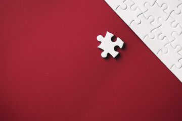 Clean puzzle elements on the red background. Empty puzzle piece on the table. Teamwork concept.