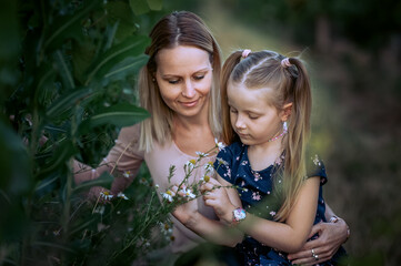 Mother and daughter in a loving embrace. Mother and little daughter playing together. 