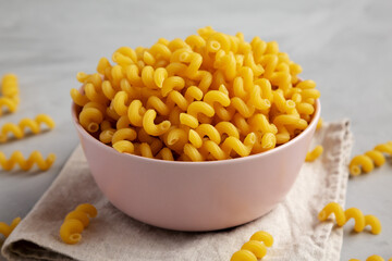Homemade Organic Dried Riccioli Pasta in a Pink Bowl, side view.