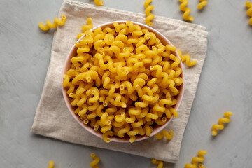Homemade Organic Dried Riccioli Pasta in a Pink Bowl, top view. Flat lay, overhead, from above.
